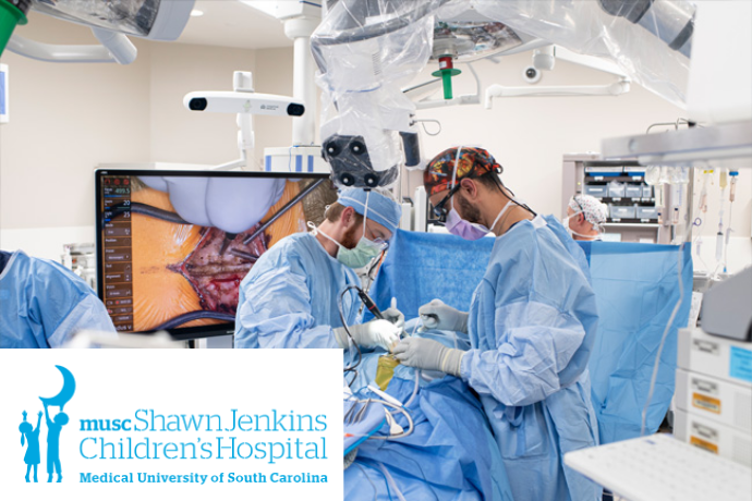 surgeons operating with a monitor in the background